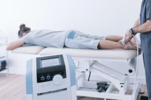 The physiotherapist treating a man using equipment for radio therapy